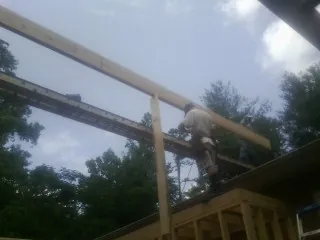 Carpenter setting a ridge beam over a new addition frame — Ice Dam Removal by Roofing Brothers in Umpqua
