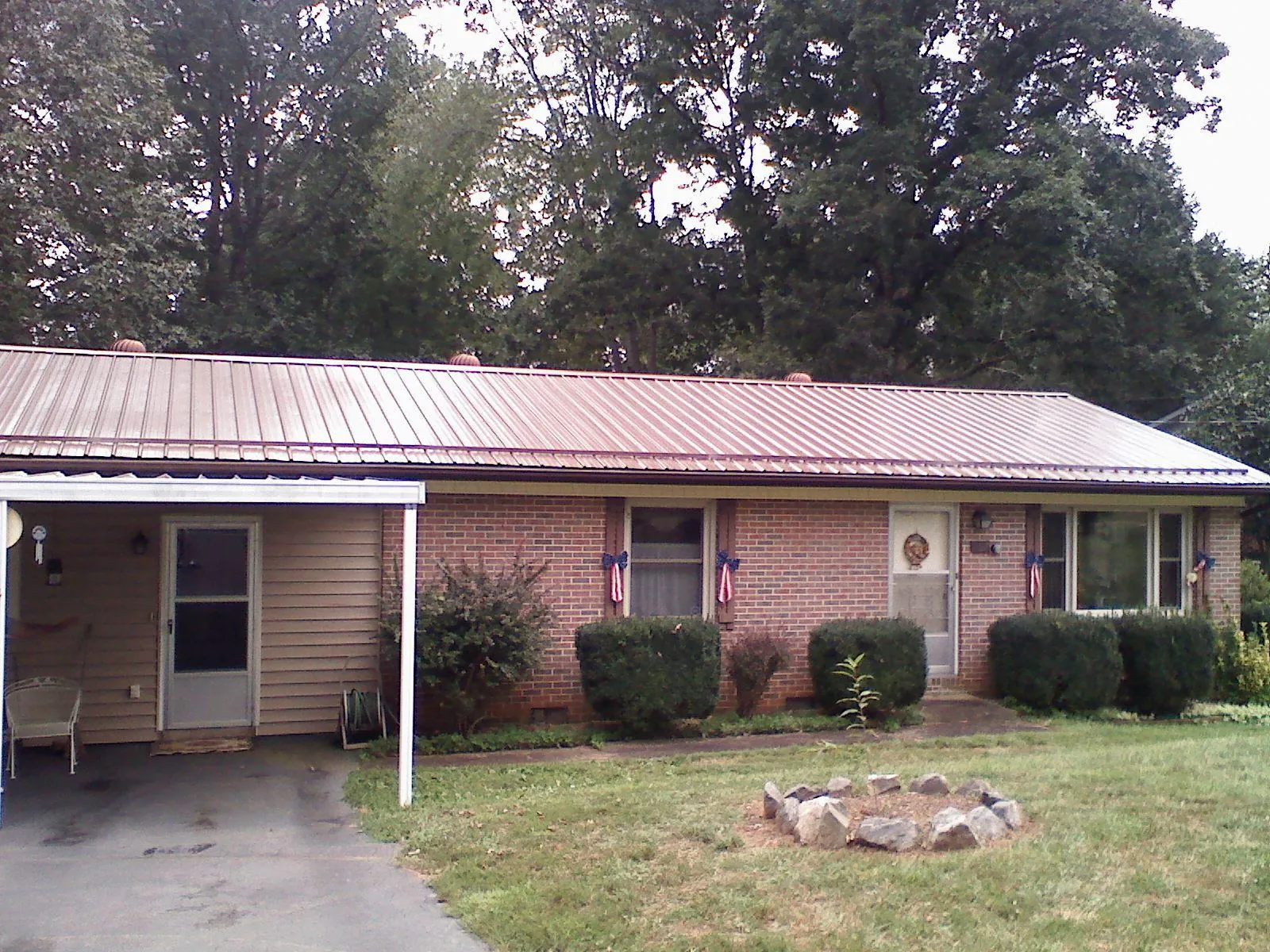 Bronze metal roof and carport on a brick ranch home — Roof Repair work by our crew in Umpqua